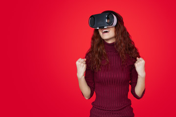 Excited redhead teenage girl in VR glasses