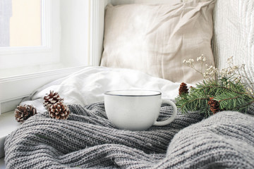 Cozy winter morning breakfast in bed still life scene. Steaming cup of hot coffee, tea standing...