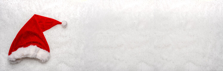 chapeau de p&egrave;re no&euml;l rouge sur de la neige en format panoramique