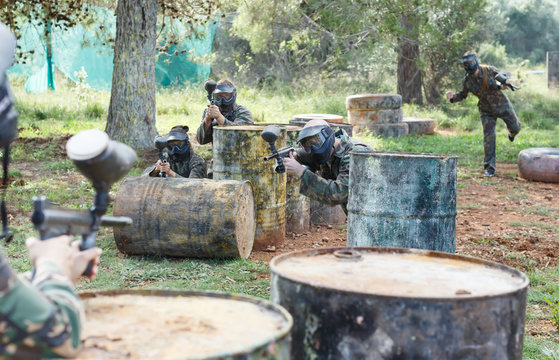 Team of friends paintball players  playing together in shootout
