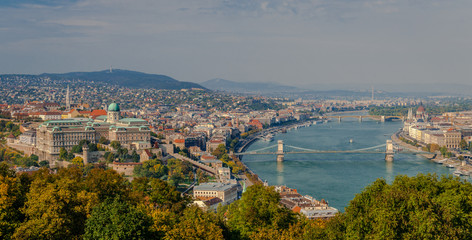 Obraz premium Panoramic view of Budapest and river Danube, in Hungary. The Castle of Buda is on the left and the bridge that spans river Danube is the famous Chain Bridge. Photo taken from the Gellert Hill.