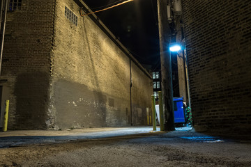 Dark and scary downtown urban city street corner alley with an eerie vintage industrial warehouse...
