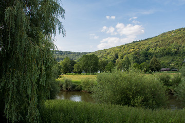 Small lake between green hills with blue skye