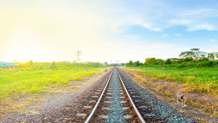 railway tracks in a rural area with bright moring sunrise, panorama view