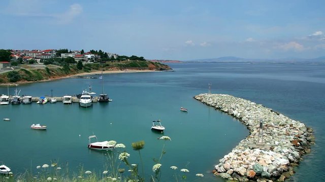 Bay with parking for yachts and boats on aegean sea, fishing boat on the pier 
