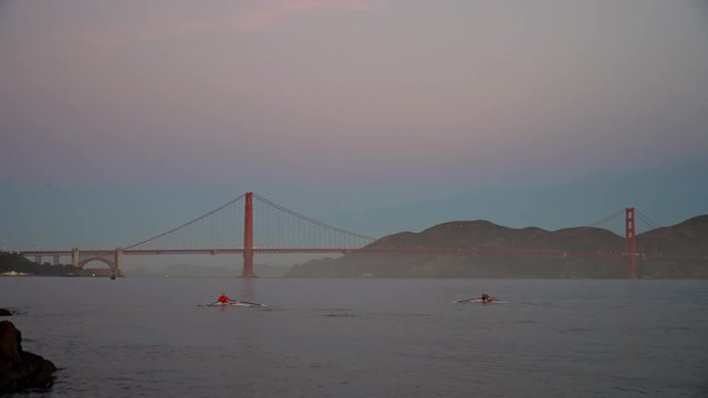 Two racing shells on San Francisco Bay, heading for the Golden Gate Bridge.  Early morning, sun not quite up.