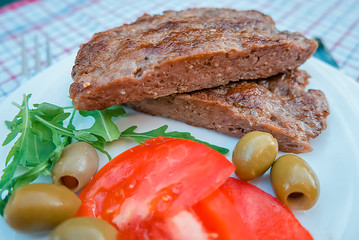 Pleskavitsa. Dish of Balkan cuisine from minced meat with vegetables on white plate.