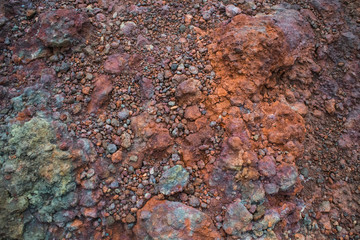 Nature abstract  brown lava stone background featuring details of volcanic stones at slope of Etna volcano, Sicilia, Italy. Various colors are attributed to various minerals in lava.