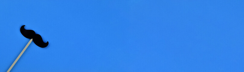 Black mustaches on light blue background representing an annual event involving the growing of...