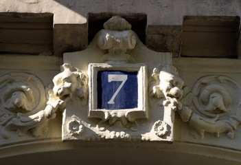 Numéro 7, chiffre blanc et bleu sur façade de pierre blanche