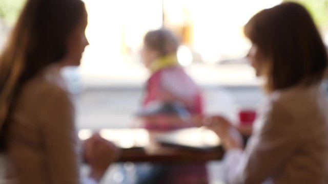 Blurred silhouette two women talking in cafe