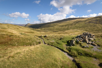 Fototapeta na wymiar Cumbria Way hike over stake pass with shining blue weather