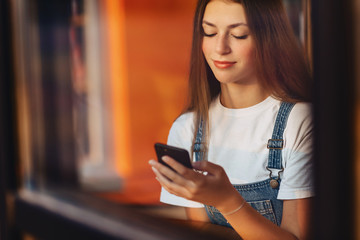 young attractive pretty girl at cafe with coffee and phone throuth window glass