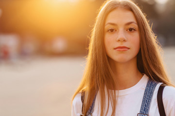 Fototapeta premium closup portrait attractive pretty girl with briefcase walk on street at morning sunrise lights