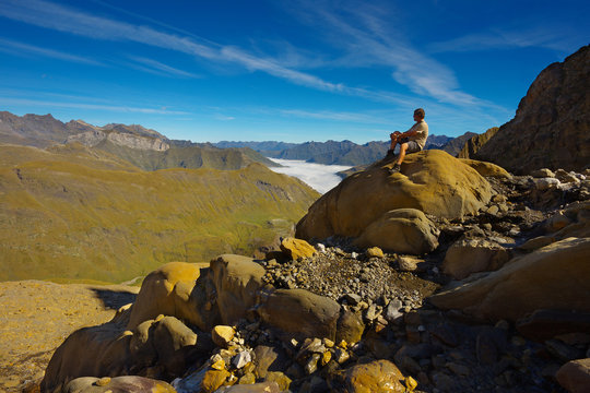 Resting tourist on the stone with mountains on backround, Pyrenees