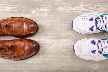 Men's classic brown leather shoes and sneakers on the wood floor. Men Brown Shoes.