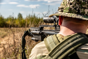 Fototapeta premium special forces, soldier assault rifle with silencer, optical sight. behind cover waiting in ambush