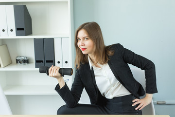 Business, fitness in office and people concept - Satisfied woman in office holding dumbbell in hand