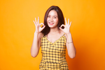Asian woman show double OK hand sign and smile.
