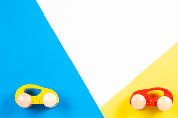 Two wooden toy cars on colorful background