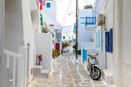 Fototapeta Traditional houses with blue doors and windows in the narrow streets of greek village in Mykonos in Greece