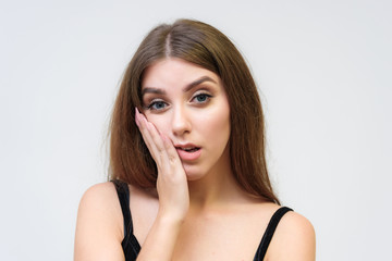 Fototapeta premium Studio portrait of a smiling happy beautiful brunette girl on white background.