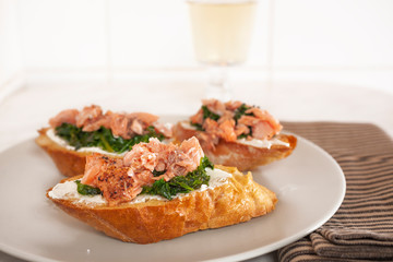 Smoked salmon and spinach canape served on white plate