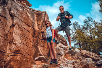 Father and daughter descending from a cliff