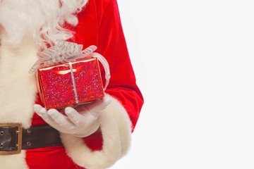 Photo of Santa Claus gloved hands holding red giftbox, isolated 