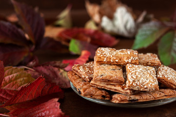 Plate of tasty cookies against the background of autumn foliage