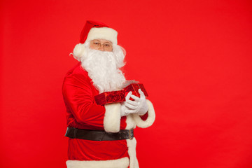 Photo of Santa Claus gloved hands holding red giftbox