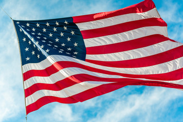 Obraz premium American flag waving in blue cloudy sky