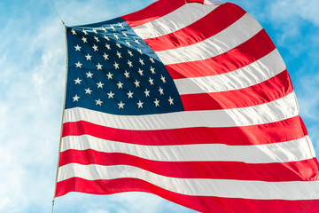 American flag waving in blue cloudy sky