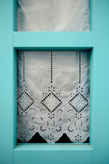 Wooden window with lace curtain