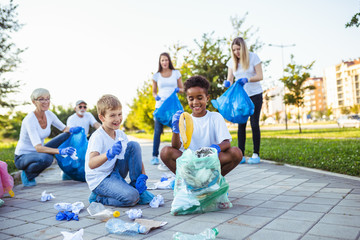 Volunteers with garbage bags cleaning up garbage outdoors - ecology concept.