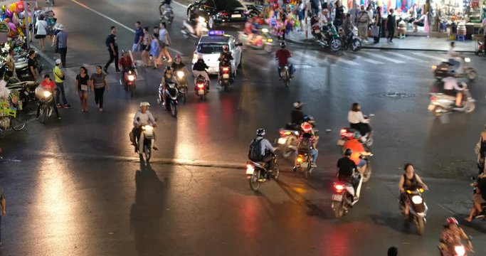 Hanoi, Vietnam-09/2018: Night traffic in downtown Hanoi capital with lots of motorcycles, motorbike, bus, car, and people walking transport on the road. Aerial view city in rush hour, traffic noise