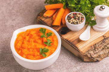 Bright tasty pureed carrot soup in clay bowl