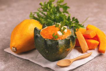 Bright tasty pureed pumpkin soup served in a hollowed pumpkin