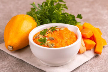 Bright tasty pureed pumpkin soup with ingredients