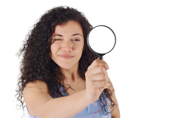 Happy smiling young woman looking through a magnifying glass