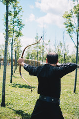 Archer in traditional clothes shooting an arrow