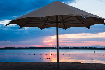 beach with umbrella at sunset