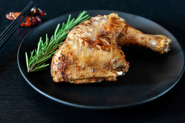 Grilled chicken leg with spices is on the table in a dish