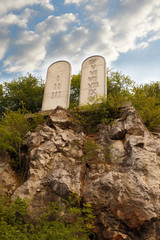 Stone tablets on a rocky hill with carved 10 commandments