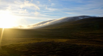 A midsummer night in Iceland. Clouds are floating down a mountain.