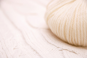 Fototapeta na wymiar white ball of crochet thread in a white scarf, cozy white patterned scarf