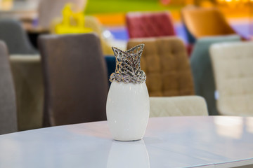 Beautiful white vase with silver decor in the interior on the table