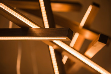 Led light lamp illuminated. Installation of a geometric hanging wooden chandelier - Powered by Adobe