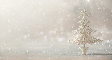 Silver glitter Christmas tree on grey background with lights bokeh, copy space. Greeting card for new year party. Festive holiday concept. Banner
