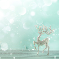 Obraz na płótnie Canvas Silver glitter Christmas deer on blue background with lights bokeh, copy space. Greeting card for new year party. Festive holiday concept. Square crop